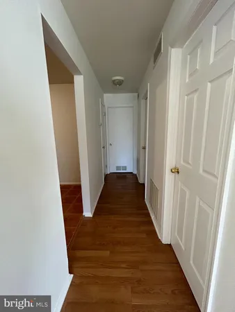 a view of a hallway with wooden floor and entryway
