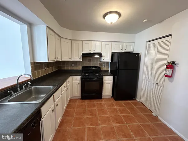 a kitchen with a refrigerator sink and wooden cabinets