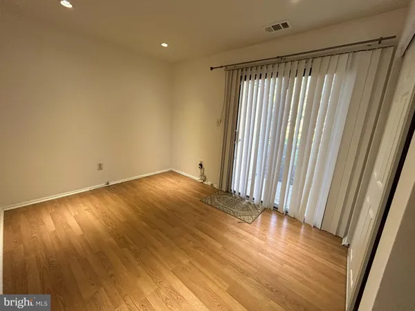 a view of a room with wooden floor and a window