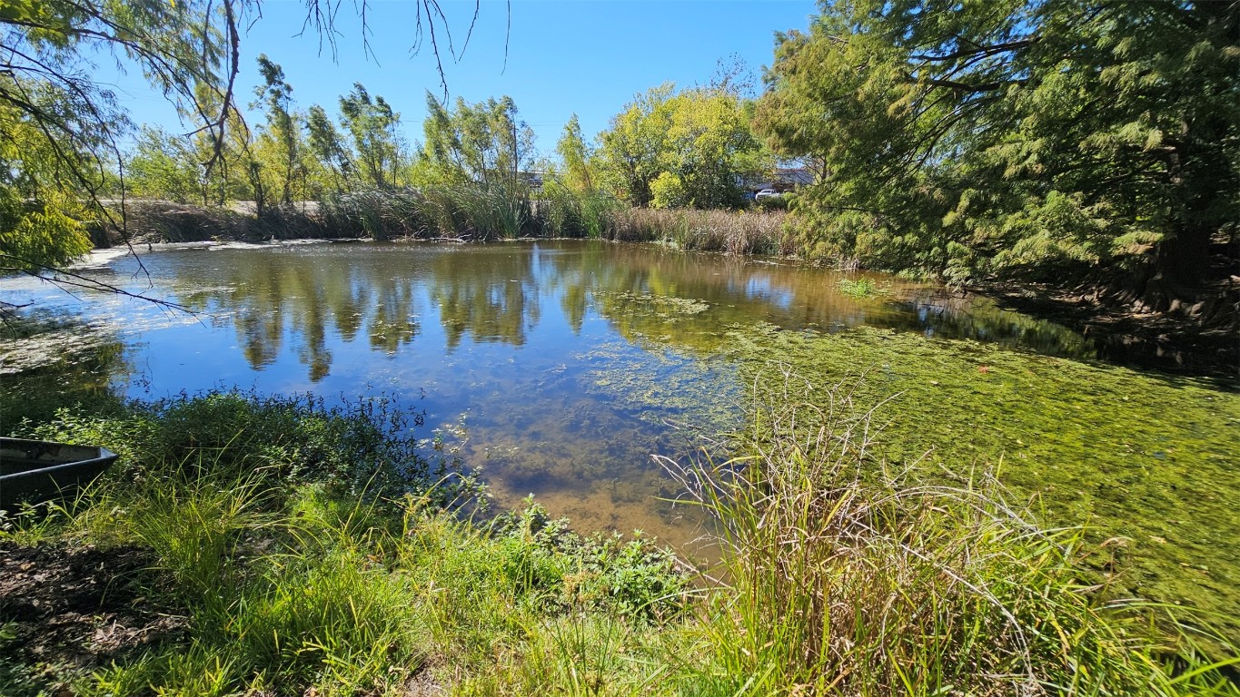 170 Interstate Drive, Unit B Buda, TX 78610 - Photo 11 of 11 a view of a lake with a big yard and large trees