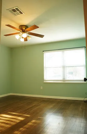 a view of a room with a window and wooden floor