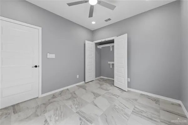 a view of an empty room with a chandelier fan
