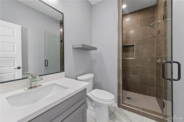 a bathroom with a sink a toilet and shower