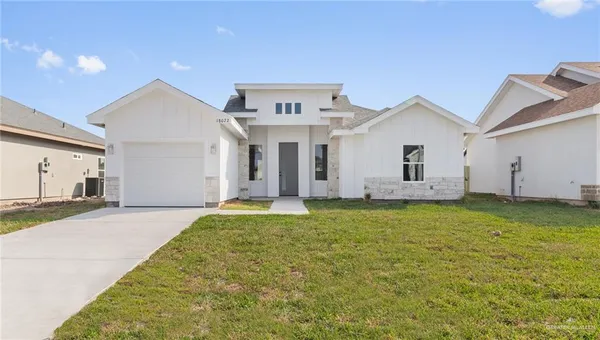 a view of a house with a backyard and a garage