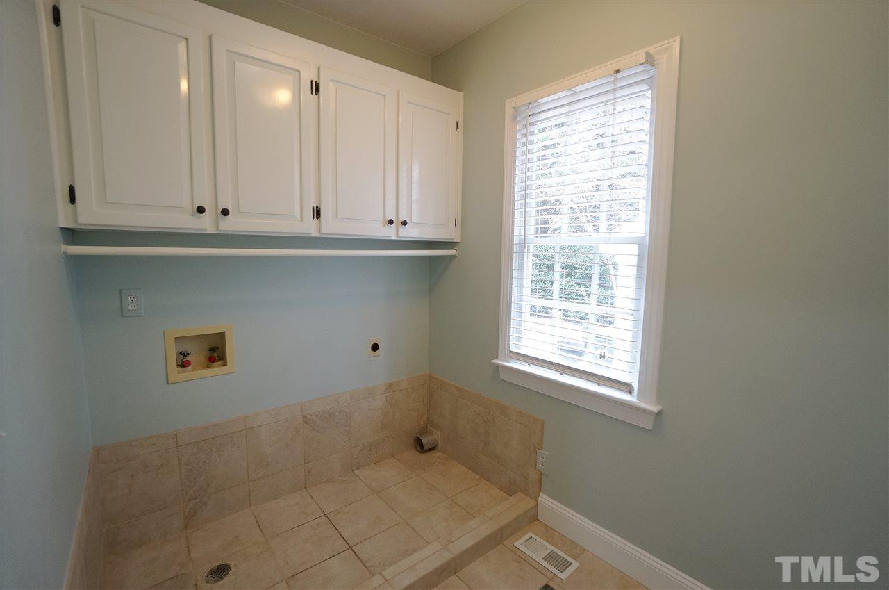 204 Veranda Court Raleigh, NC 27615 - Photo 23 of 25 Laundry Room has tile floor with design detail. Storage Cabinets & Large Linen / Storage Closet.