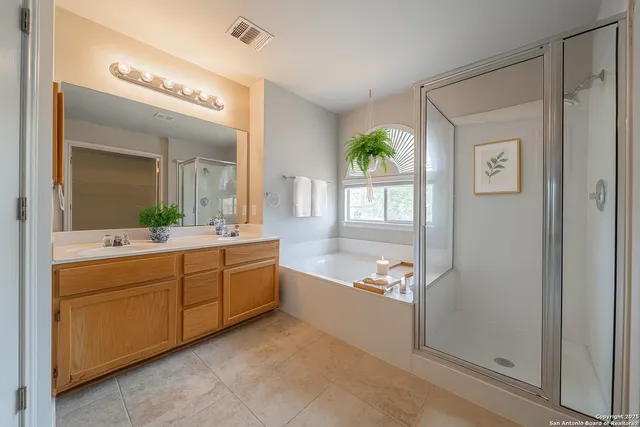a spacious bathroom with a granite countertop sink mirror and a bathtub