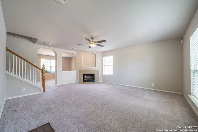 an empty room with fireplace and windows