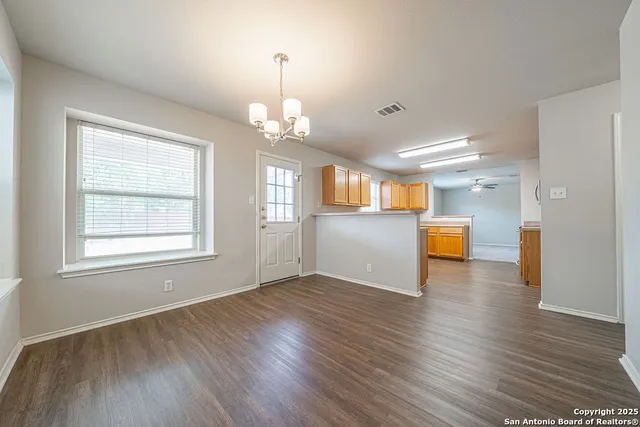a view of a big room with wooden floor and windows