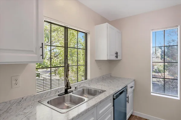 a kitchen with granite countertop a sink stainless steel appliances and cabinets