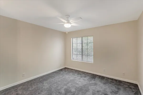 an empty room with a fan and a fan