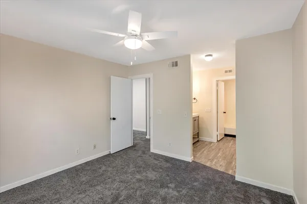 an empty room with a window and a ceiling fan