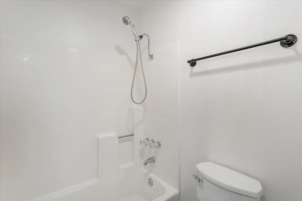 a bathroom with a granite countertop toilet sink and shower