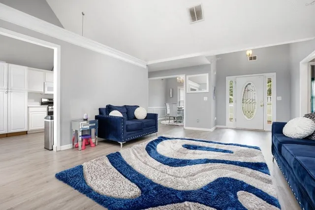 a living room with furniture and wooden floor