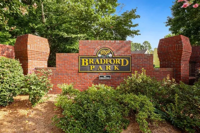 a sign that is sitting on a brick wall