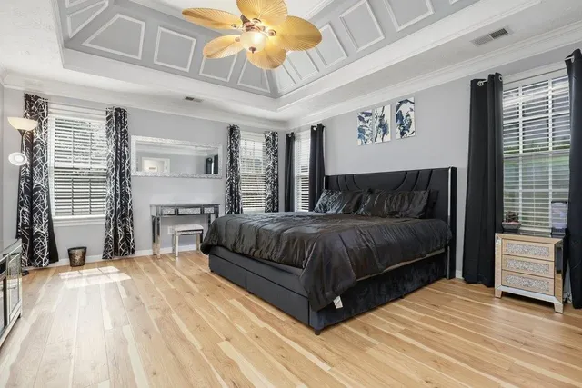 a spacious bedroom with a bed and a chandelier