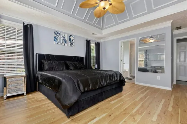 a bedroom with a large bed and a chandelier