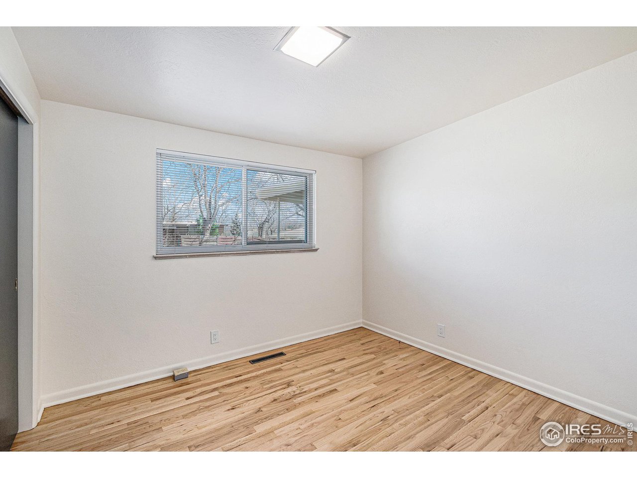 613 Skyline Drive Fort Collins, CO 80521 - Photo 14 of 19 an empty room with wooden floor and window