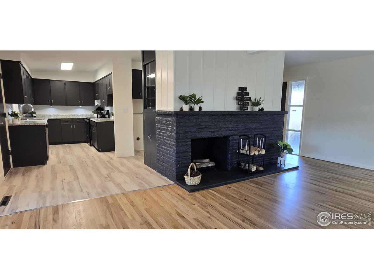 613 Skyline Drive Fort Collins, CO 80521 - Photo 3 of 19 a living room with a wooden floor and a fireplace