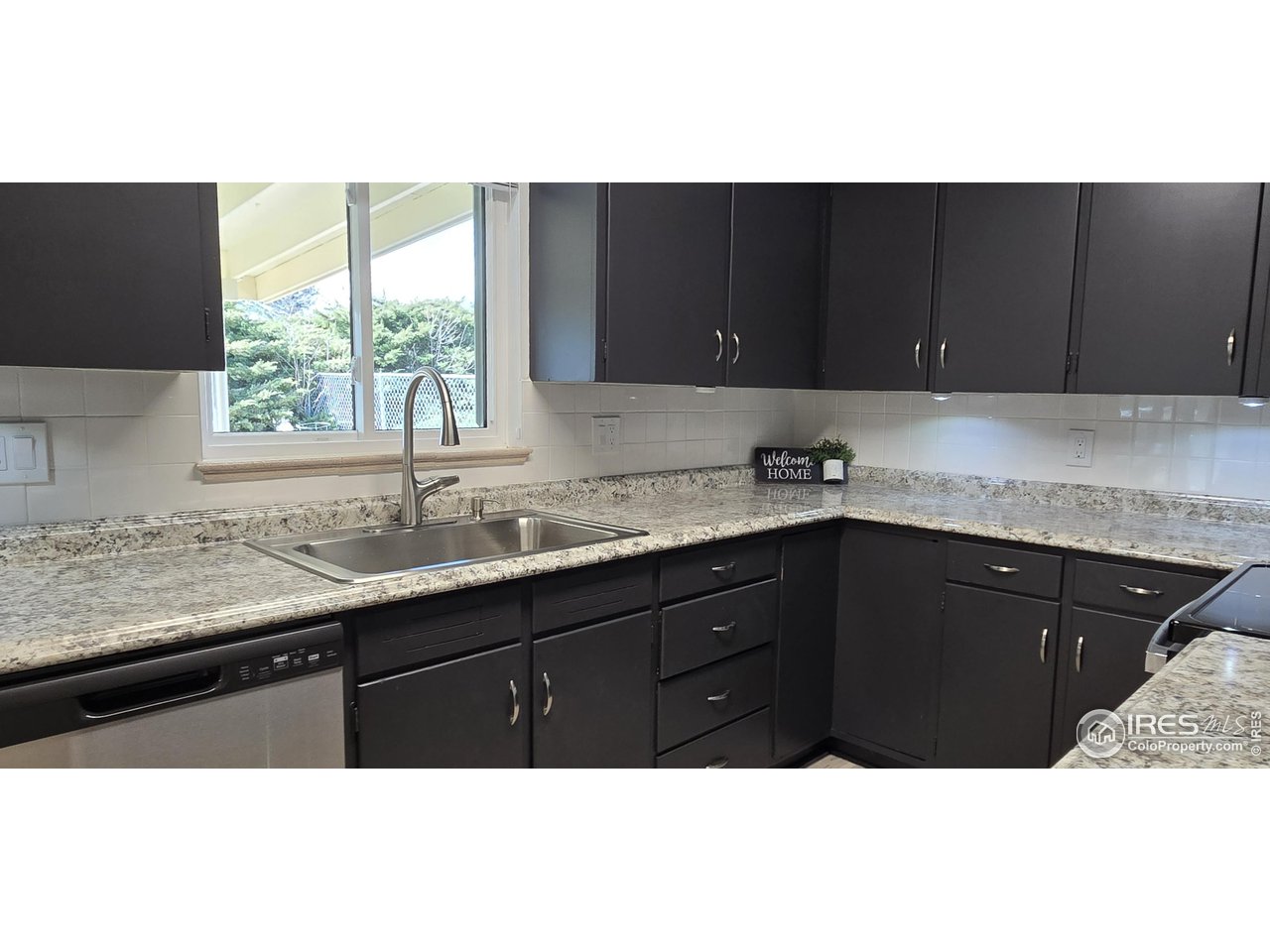 613 Skyline Drive Fort Collins, CO 80521 - Photo 7 of 19 a kitchen with granite countertop a sink and cabinets