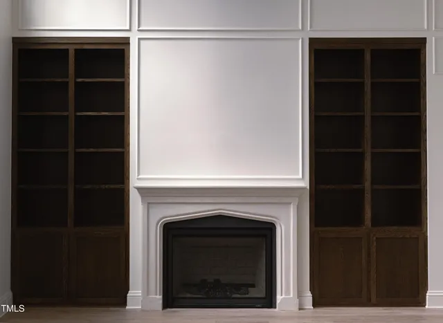 a view of an empty room with a fireplace and a window