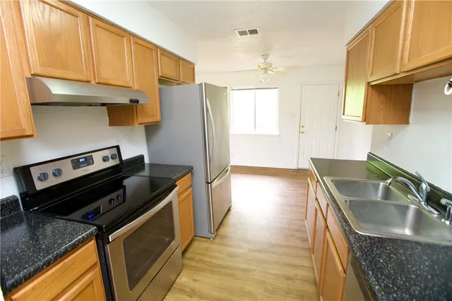 a kitchen with a sink stove and refrigerator
