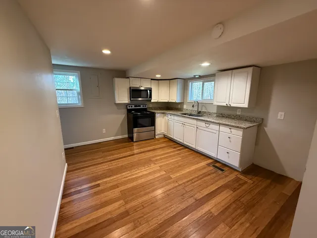 a kitchen with stainless steel appliances granite countertop a stove a sink and a refrigerator