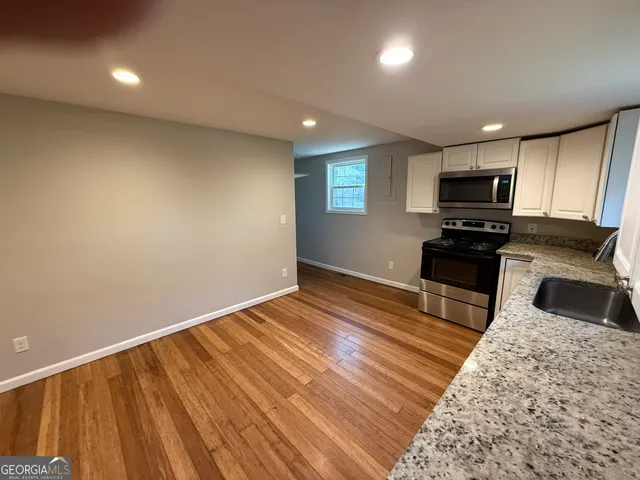 a kitchen with granite countertop wooden cabinets and stainless steel appliances