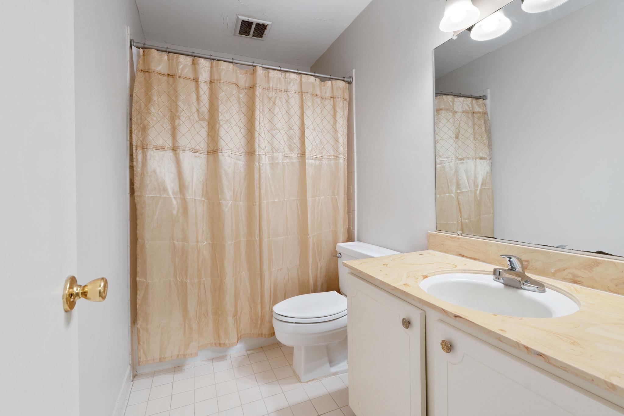 5726 Quince Road, Unit 9 Memphis, TN 38119 - Photo 17 of 21 a bathroom with a sink a toilet and shower curtain