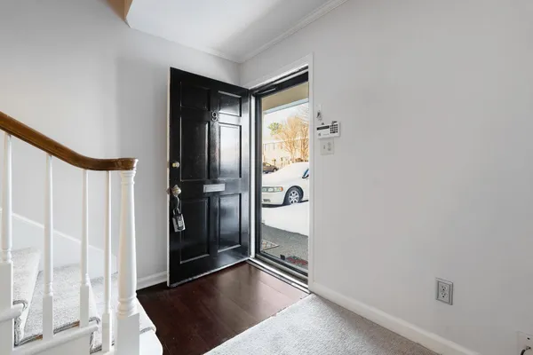 a view of a hallway with wooden floor and a living room