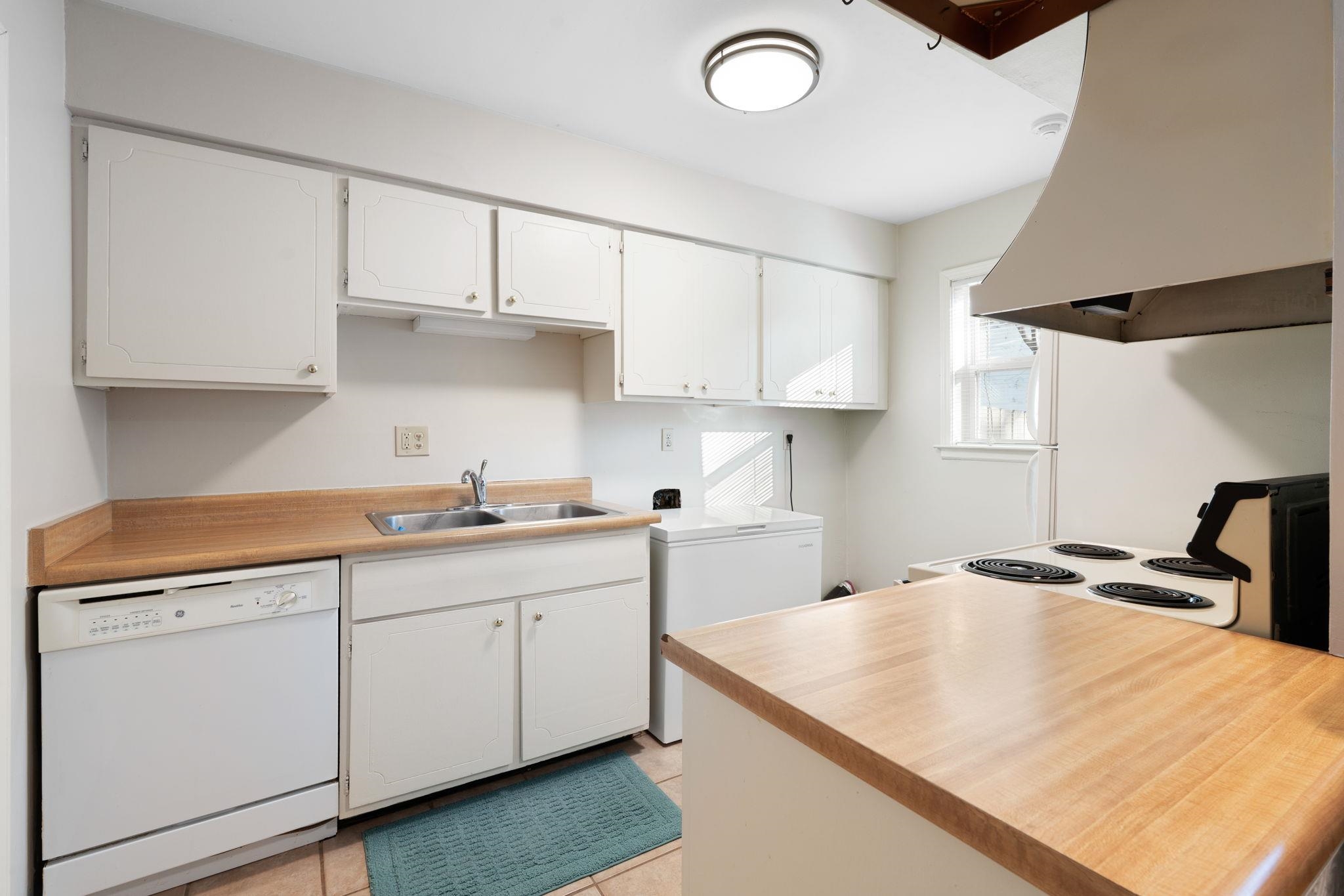 5726 Quince Road, Unit 9 Memphis, TN 38119 - Photo 8 of 18 Kitchen featuring ventilation hood, white appliances, light countertops, white cabinetry, and light tile patterned floors