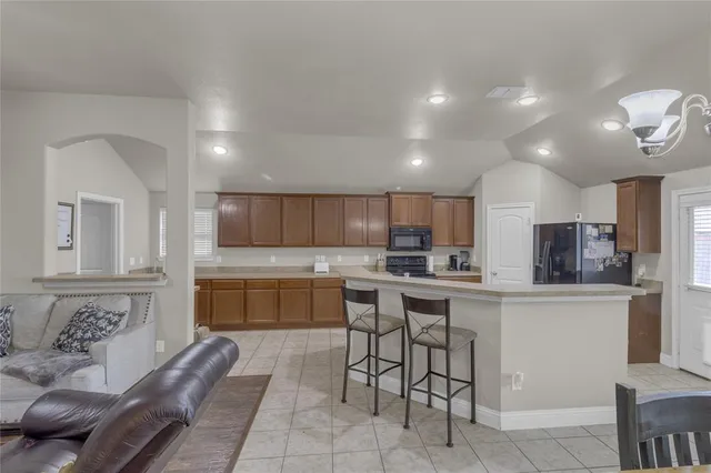 a kitchen with kitchen island stainless steel appliances a sink and cabinets
