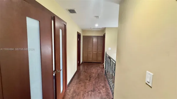 a view of a livingroom with wooden floor and a flat screen tv
