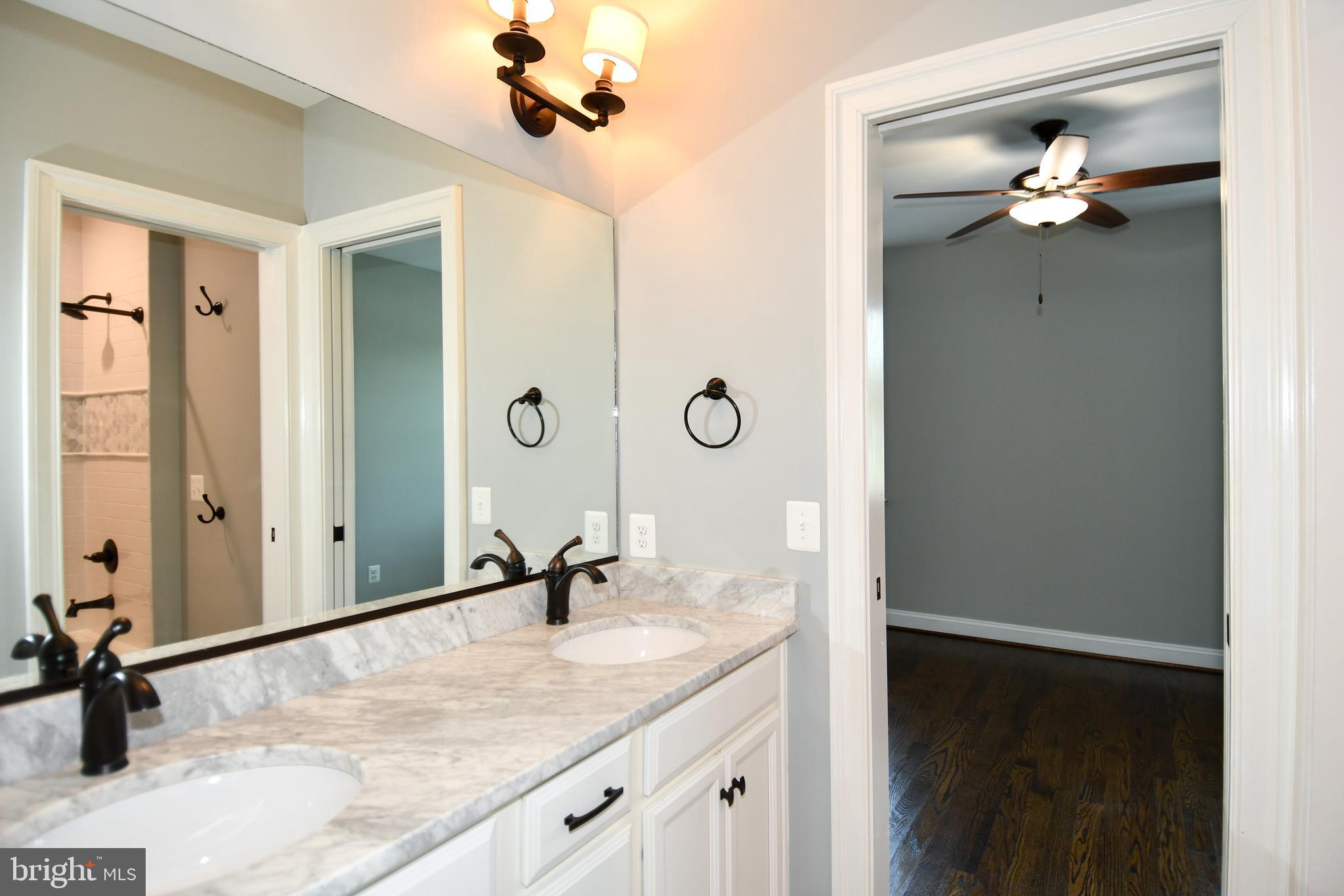 497 North Abingdon Street Arlington, VA 22203 - Photo 28 of 64 a bathroom with a granite countertop sink a mirror and shower