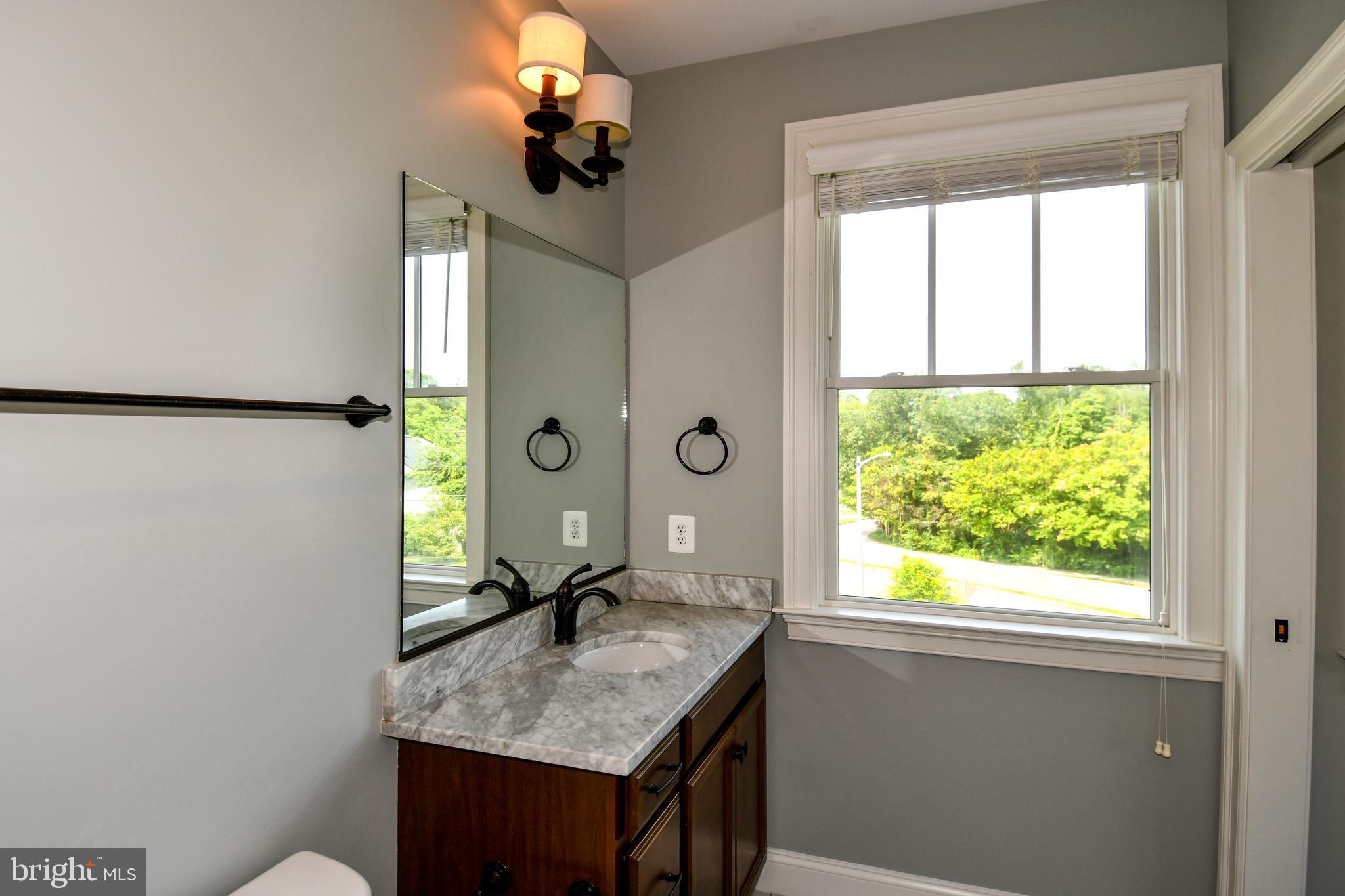 497 North Abingdon Street Arlington, VA 22203 - Photo 35 of 64 a bathroom with a granite countertop sink a toilet and a window