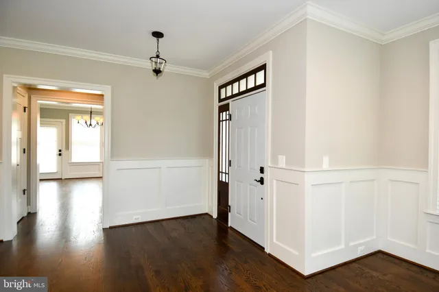 an empty room with wooden floor fireplace and windows
