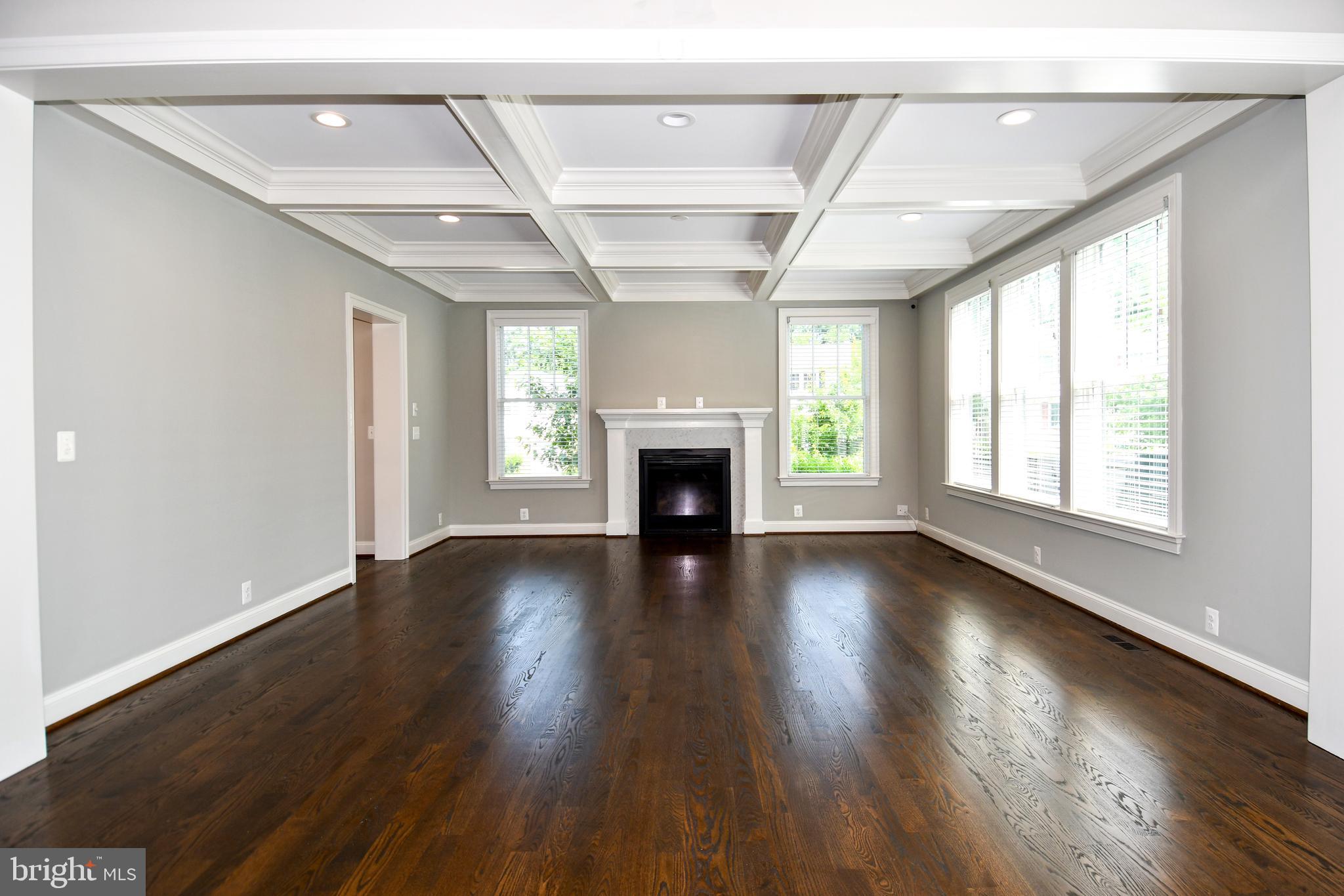 497 North Abingdon Street Arlington, VA 22203 - Photo 9 of 64 an empty room with wooden floor fireplace and windows