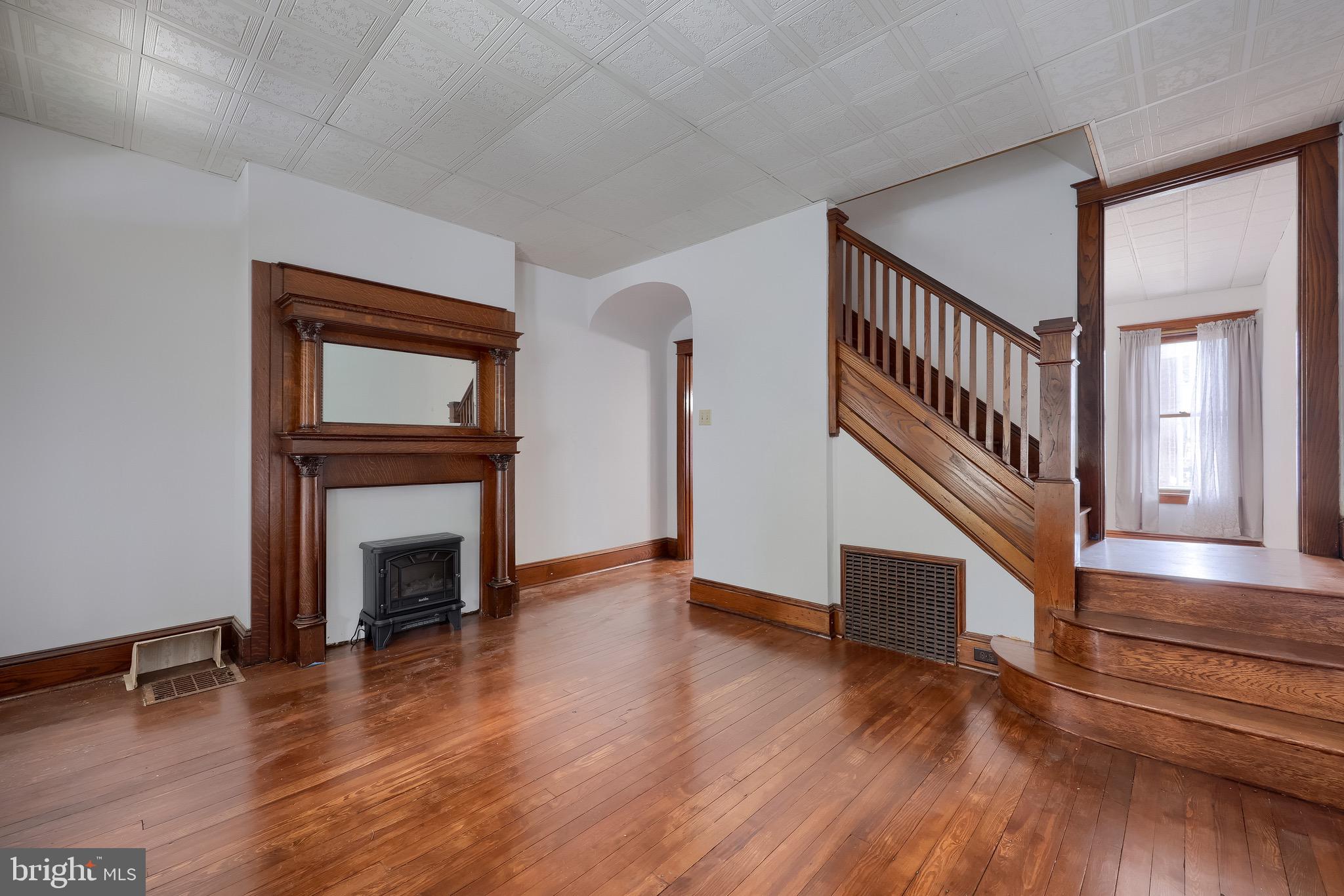 720 1st Street Lancaster, PA 17603 - Photo 18 of 50 a view of an empty room with wooden floor a fireplace and a window
