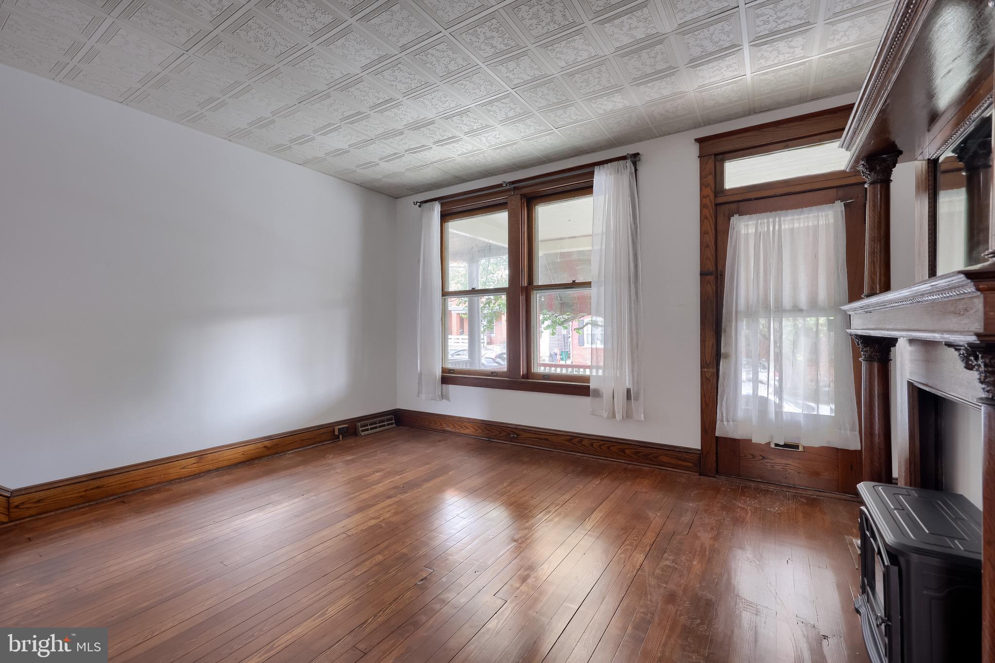 720 1st Street Lancaster, PA 17603 - Photo 10 of 50 an empty room with wooden floor fireplace and windows