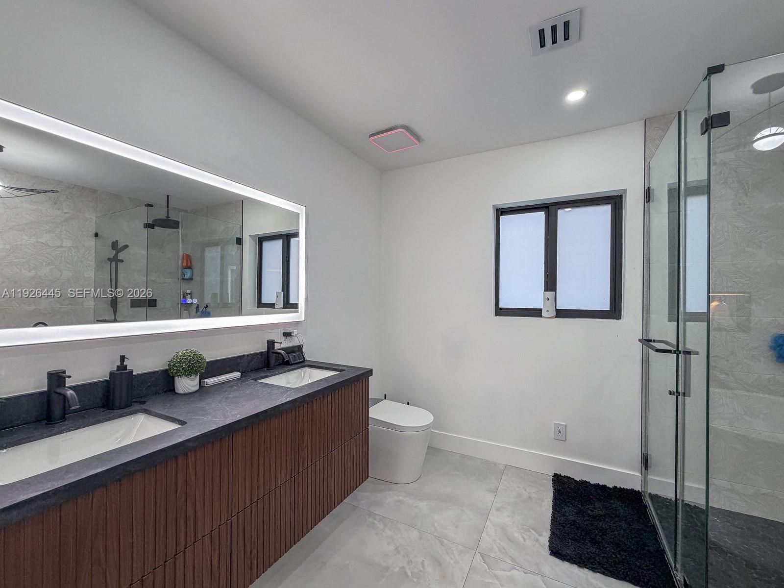 7840 Southwest 18th Terrace Miami, FL 33155 - Photo 14 of 28 a bathroom with a granite countertop sink a toilet a mirror and vanity