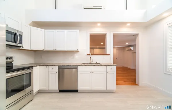 a kitchen with stainless steel appliances granite countertop a stove and a microwave