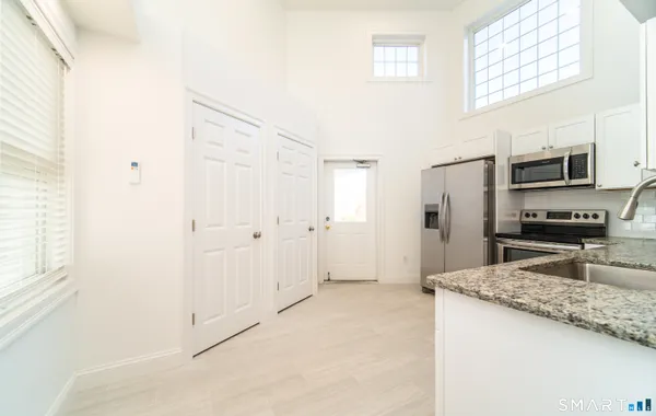 a kitchen with stainless steel appliances granite countertop a refrigerator and a sink