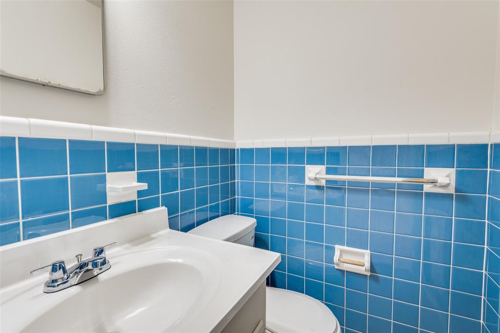 402 West Grauwyler Road Irving, TX 75061 - Photo 14 of 22 a bathroom with a sink a toilet and a mirror