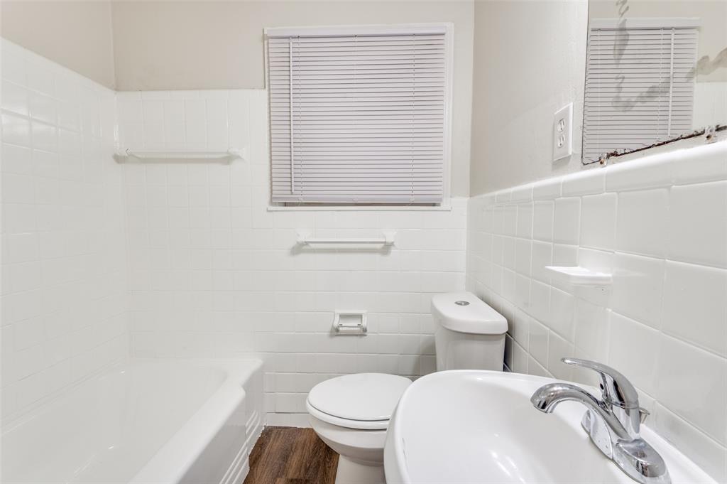 402 West Grauwyler Road Irving, TX 75061 - Photo 18 of 22 a white toilet sitting next to a bathroom sink