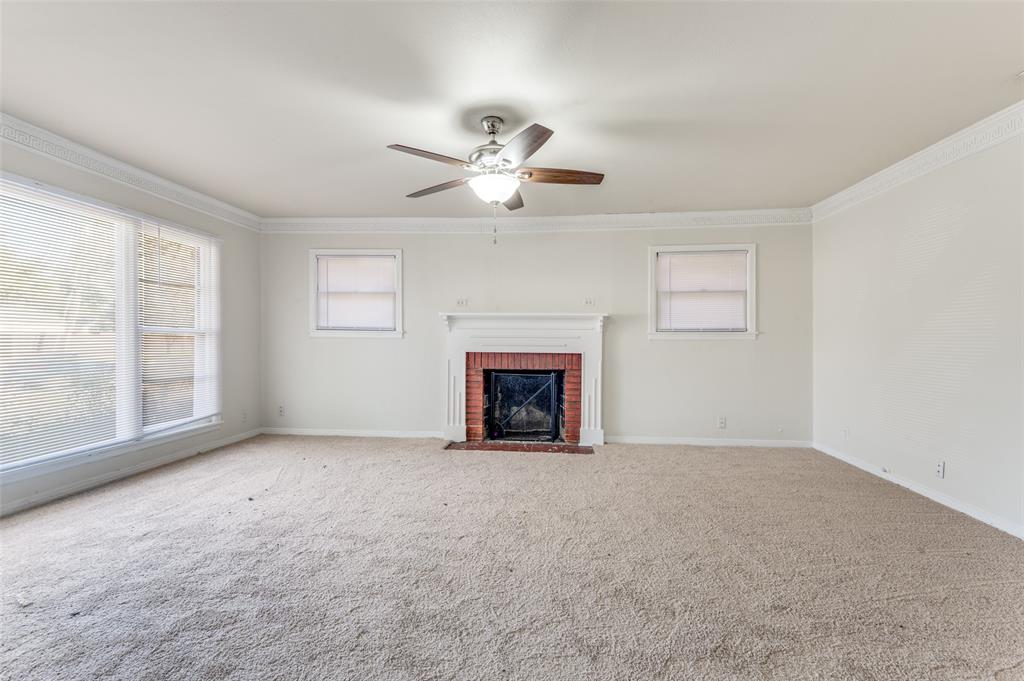 402 West Grauwyler Road Irving, TX 75061 - Photo 4 of 22 a view of an empty room with a fireplace and a window