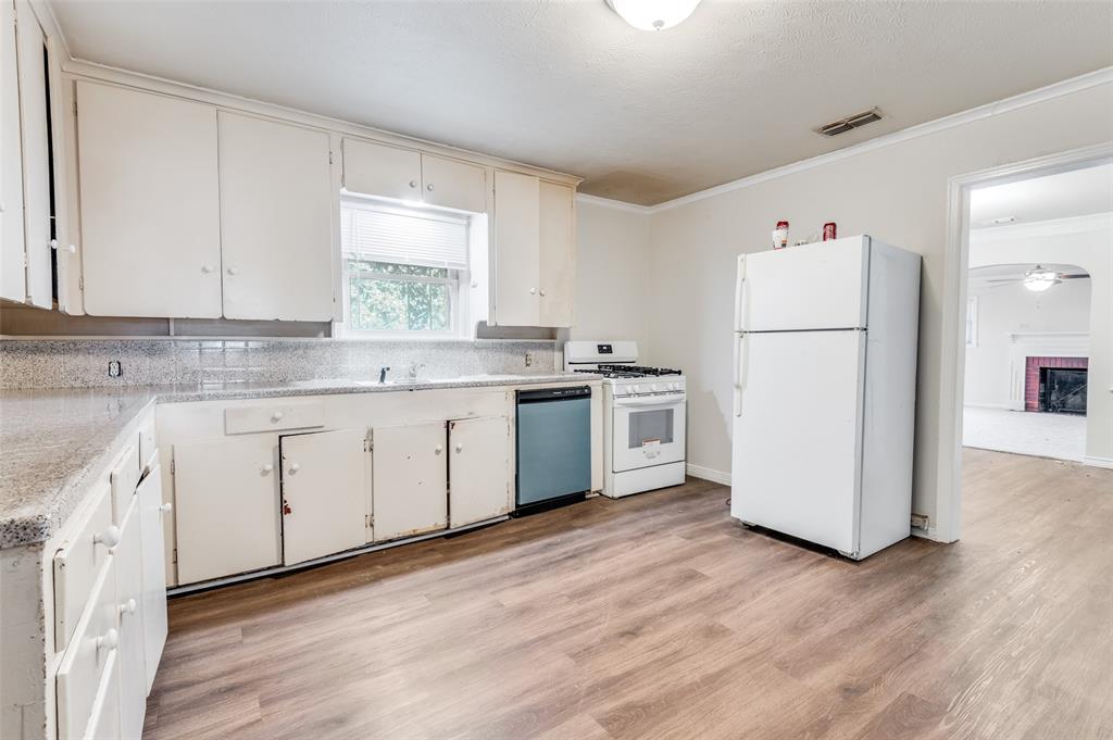 402 West Grauwyler Road Irving, TX 75061 - Photo 9 of 22 a kitchen with a white cabinets white stainless steel appliances and wooden floors
