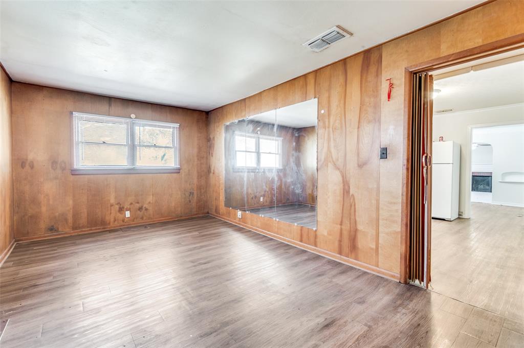 402 West Grauwyler Road Irving, TX 75061 - Photo 10 of 22 an empty room with wooden floor and windows
