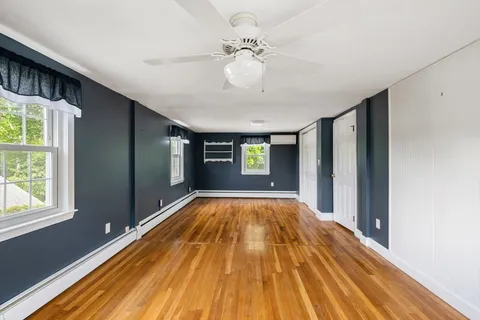 a view of empty room with wooden floor
