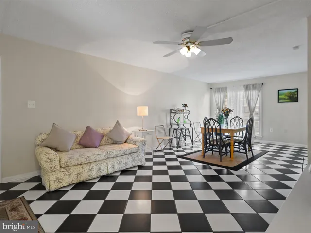 a living room with furniture and a black white checkered floor