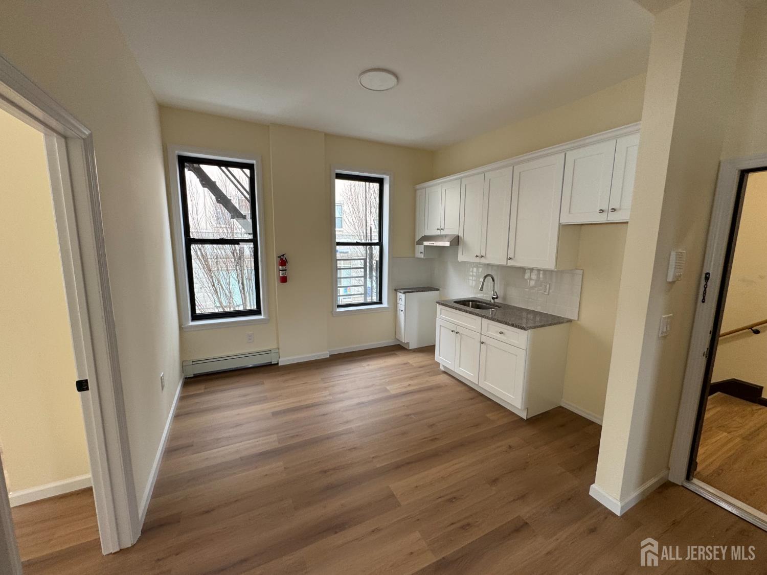290 King Street, Unit 1 Perth Amboy, NJ 08861 - Photo 1 of 1 a kitchen with wooden floors and white appliances