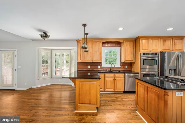 a view of a room with wooden floor and a ceiling fan